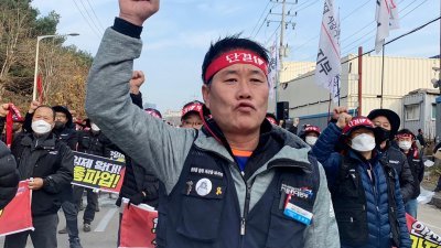加入罢工行列的韩国货运卡车司机，上周四在交通枢纽义王市游行抗议。（图取自路透社）