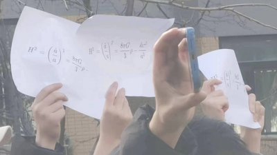 在中国清华大学校园内的抗议活动上，有3名学生高举写著“弗里德曼方程”的白纸。（图取自推特/Nathan Law 罗冠聪）