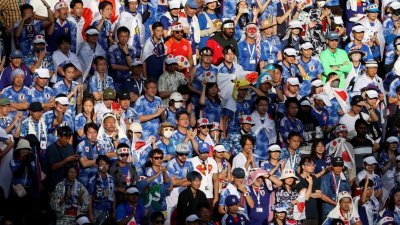 日本周日在2022卡塔尔世界杯足球赛小组赛第2战出战哥斯达黎加，场边未戴口罩的日本球迷为自家球员加油。（图取自法新社）