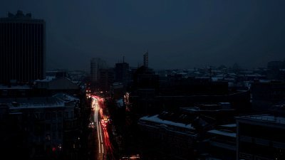 乌克兰的能源基础设施遭到俄军，面临大规模停电的首都基辅，入夜后漆黑一片，只有路上行驶的车辆灯光带来的光影。（图取自路透社）