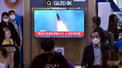 朝鲜周五试射导弹，民众在韩国首尔车站内观看电视播报的相关新闻。（图取自法新社）