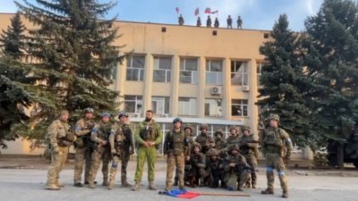 社交媒体视频截图显示，一群乌克兰士兵在利曼行政办公室前发表声明，俄罗斯国旗被弃之于他们脚下。在发表完声明后，屋顶上方的乌军将俄罗斯国旗从高处抛下，并竖起乌克兰国旗。（图取自乌克兰武装部队第81空降旅/路透社）