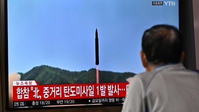 在首尔的一个火车站，一名男子正在观看朝鲜于周二试射导弹导弹，并飞越日本领空的相关新闻报导。（图取自法新社）
