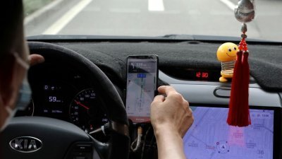 中国北京一名网约车司机看著手机，上面显示滴滴应用程序上的导航地图。（图取自路透社档案照）