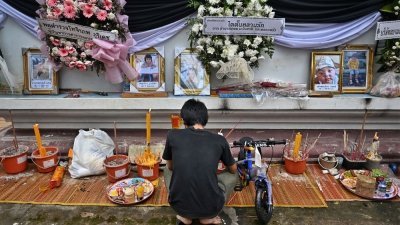 遇难者亲属们周一在寺庙为托儿所命案中丧生的人举行葬礼。有的家长为逝世的孩子准备脚车等玩具送葬。（图取自法新社）