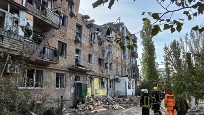 乌克兰官员表示，俄罗斯周四再发射导弹轰炸乌克兰南部尼古拉耶夫市。图为该市一栋公寓遭俄军炸毁，救援人员在现场展开搜救。（图取自路透社）