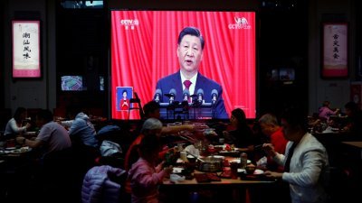 在中国北京一家餐馆的大屏幕上，直播著中共中央总书记习近平在二十大的演说。（图取自路透社）