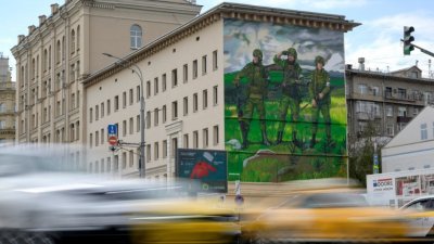 在俄罗斯首都莫斯科一座建筑的墙壁上，壁画描绘了3名俄罗斯武装军人站在战场上，制服上印有Z符号。（图取自法新社）