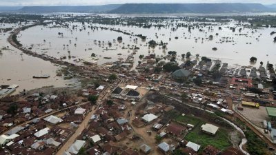 上周四在尼日利亚洛科贾，城镇彷如被洪水包围，一条被洪水淹没的道路上依稀可以看到车辆。（图取自路透社）