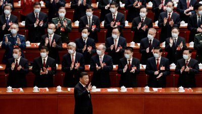 中共二十大周日在北京人民大会堂开幕，中共中央总书记习近平进场时，全场起立鼓掌，他也挥手致意。（图取自路透社）