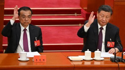 中共总书记习近平（右）和中国总理李克强，在周六的中共二十大闭幕会上举手投票。（图取自法新社）