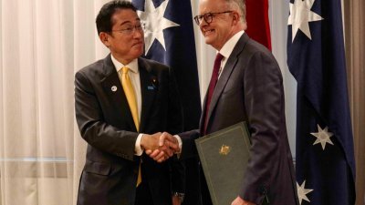 日澳周六签署更新版安全合作协议，应对地区安全环境变化。日本首相岸田文雄（左）澳洲总理与阿尔巴尼斯在签署仪式上欣喜握手。（图取自法新社）