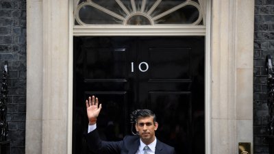 苏纳克在周二出任英国新一任首相，他当天在唐宁街10号外向传媒挥手致意。（图取自法新社）