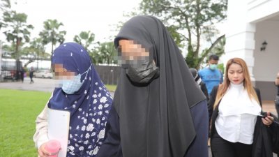 女嫌犯（左2）在家人陪同下前往新山法庭。