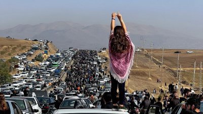 成千上万的人在周三前往位于阿米尼家乡的墓地，一名没有戴头巾的女子将双手高举过头站在车顶上，以此方式纪念阿米尼离世40天。（图取自UGC/法新社）