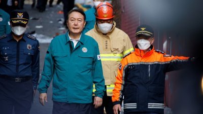 韩国总统尹锡悦（左二）周日到梨泰院踩踏事故地点了解善后情况。（图取自路透社）