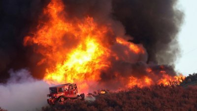 在美国加利福尼亚州卡斯泰克，一辆推土机在燃烧的Route Fire边缘工作。（图取自路透社）