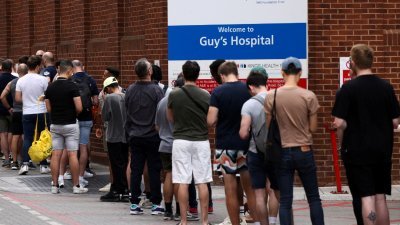 日前在英国伦敦市中心盖伊医院的诊所，人们排队接种猴痘疫苗。（图取自路透社）