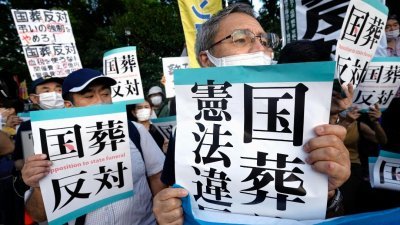 反对为前首相安倍晋三举行国葬的民众，在8月31日手持标语在日本国会大厦正门前聚集抗议。（图取自共同社/路透社）