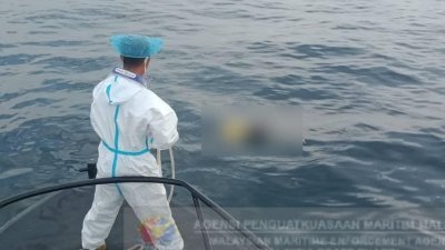 大马海事执法机构人员将漂浮在大海的男尸打捞起来。（取自该机构面书专页）