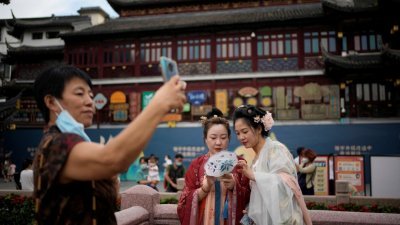 上海豫园商城近日推出中秋活动，有女市民隆重地穿上古装参与。（图取自路透社）