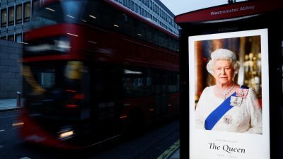 各国领袖被告知，基于英女王国葬当日将举行严格安检和道路管制，前来治丧的领袖都必须统一乘搭接驳巴士。图为伦敦市内某处巴士站，一旁的电子屏幕上映著英女王肖像。（图取自路透社）