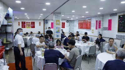 食客在香港一家餐馆内用餐。（图取自中通社）