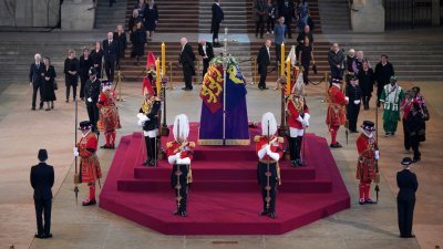 第一批在当地时间周三下午进入西敏宫的西敏厅，向女王致意的群众，缓缓地走向女王灵柩。（图取自法新社）