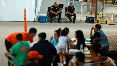 周五，在美国得州的圣安东尼市，移民资源中心外坐著一批无证移民。早前有一批移民就是从该市搭上飞机前往马萨诸塞州的玛莎葡萄园岛。（图取自路透社）