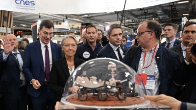 当地时间周日在巴黎会议中心举行的第73届国际宇航大会上，法国总理博尔内(左3)在法国国家太空研究中心（CNES）巴蒂斯特（左2），还有法国太空人佩斯凯（中）的陪同下，观看漫游车模型。（图取自法新社）