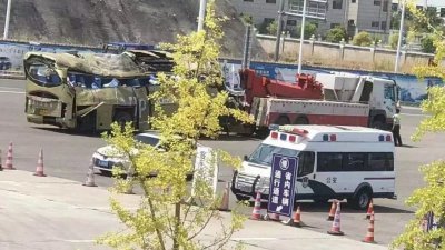 贵州一辆载有隔离者的巴士倾覆，造成27人死亡。图为事发后，拖车将严重毁损的巴士拖走。（图取自网络）