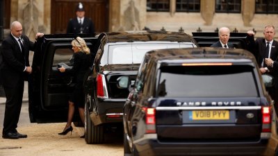 美国总统拜登和夫人吉尔从座驾“野兽”下来，进入西敏寺准备参与英女王国葬。（图取自路透社）