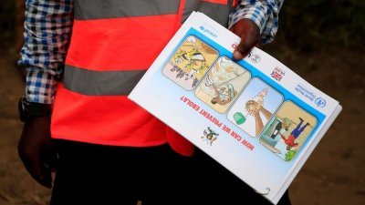 乌干达卡塞塞区，一名卫生工作者向附近的基伦博村社区展示关于埃博拉病毒以及如何防止其传播的宣传单。（路透社档案照）