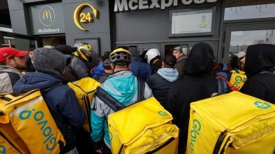 麦当劳在乌克兰首都基辅的几家分店周二重开，在其中一家分店的取餐窗口，挤满了送餐员。（图取自路透社）
