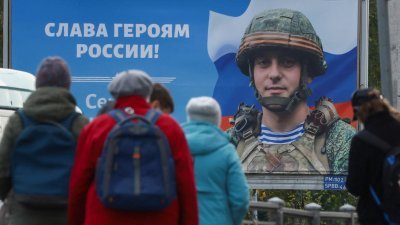 俄罗斯圣彼得堡电车站前的广告牌，展示一名俄罗斯军人肖像，并写上“荣耀归于俄罗斯英雄”的标语。（图取自路透社）