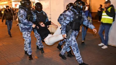 在俄罗斯首都莫斯科，警察抬走一名反对总统普京动员令的示威者。（图取自法新社）