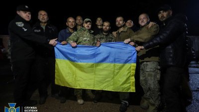 获释的乌克兰战俘，在切尔尼戈夫地区拿著国旗合影。（图取自乌克兰国家安全局新闻处/路透社）