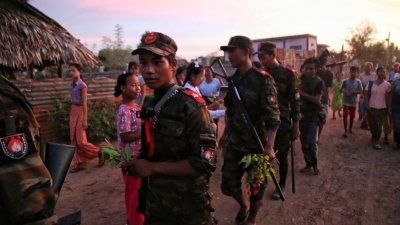  缅甸军政府为了对付反军政府分子，几个月来在中部实皆省烧毁大量村镇，如今更宣布将严惩在社交媒体支持反军政府者。图为8月16日，实皆省一处乡镇的居民献花给反对政变的武装分子。（图取自法新社）