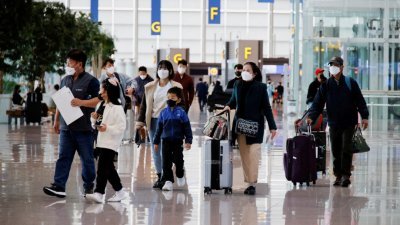 今年3月25日在韩国仁川国际机场，人们戴著口罩以防止感染新冠肺炎病毒。（图取自路透社档案照）