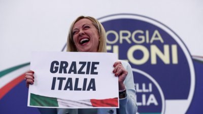 意大利兄弟党党魁梅洛尼当地时间周一凌晨，在竞选总部会晤传媒和支持者，她举著写上“感谢意大利”的牌子。（图取自路透社）