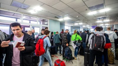 来自俄罗斯的人们周日在阿尔坦堡的蒙古边境检查站等候。俄罗斯国民涌入哈萨克和蒙古边境，据报人们有时要等几个小时才能越境。（图取自法新社）