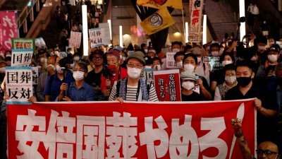 民众周日聚集在东京新宿站前抗议示威，反对为日本前首相安倍晋三举行国葬。（图取自路透社）