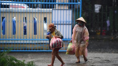 超强台风“奥鹿”来袭，越南广南省会安市的一所小学被安排作为疏散中心，让民众避难。（图取自法新社）