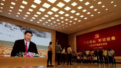 在北京的中国共产党历史展览馆，一群参访者在放映中国国家主席习近平影像的屏幕附近准备合影。（图取自路透社档案照）