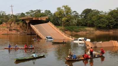 巴西亚马逊州卡雷鲁市BR-319高速公路的大桥，在周三坍塌，有车辆落入水中，赶到现场的消防人员展开搜救。（图取自路透社）