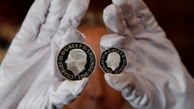 英国皇家铸币厂推出印有国王查尔斯三世肖像的5英镑硬币（左）和50便士硬币。（图取自路透社）