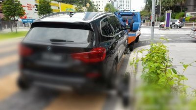 轿车因违规停车，而被新山市政局执法组拖吊。