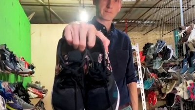 路透社记者布罗克在印尼巴淡岛一家二手商店，拿著装有追踪装置的二手运动鞋。（图取自路透社）
