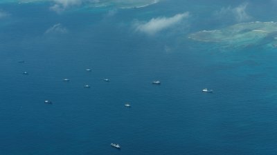 菲律宾海岸警卫队本月9日飞越南中国海南沙群岛，声称是中国海上民兵船只在中业岛附近游荡的鸟瞰图。（图取自路透社）