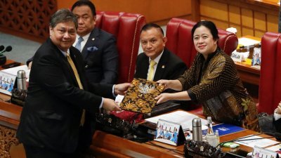 印尼经济事务统筹部长艾尔朗加（左）周二在国会就新工作和投资法发表评论后，与众议院议长普安合影留念。（图取自路透社）
